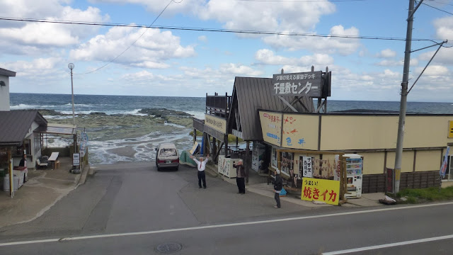 Shops near the sea, person waving