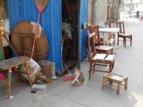 cat sitting next to a wooden chair south of Jiaoqiao New Road (滘桥新路) in Yangjiang