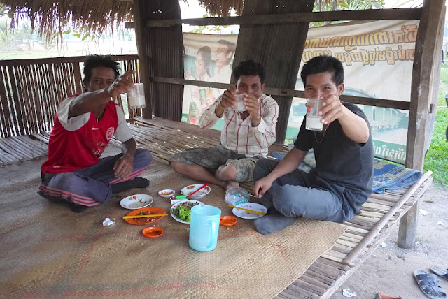three young men enjoying palm wine