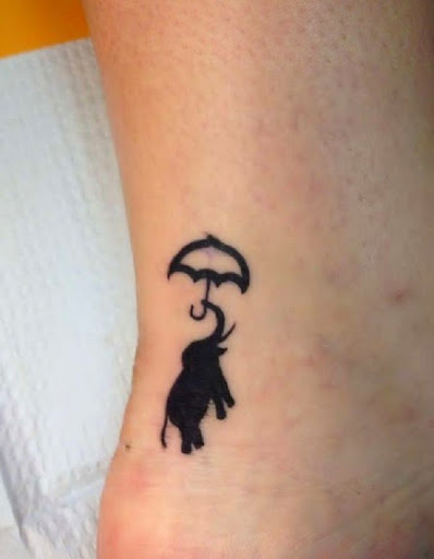 little elephant tattoo holding umbrella