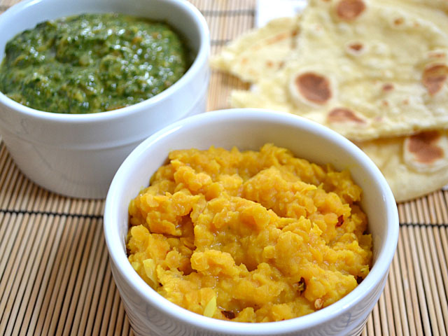 bowl of coconut lentils with a bowl of creamed spinach and naan on the side 