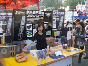 woman at a stall selling and demonstrating Nano Diamond Coating