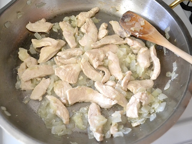 chicken added to skillet with garlic and onions 