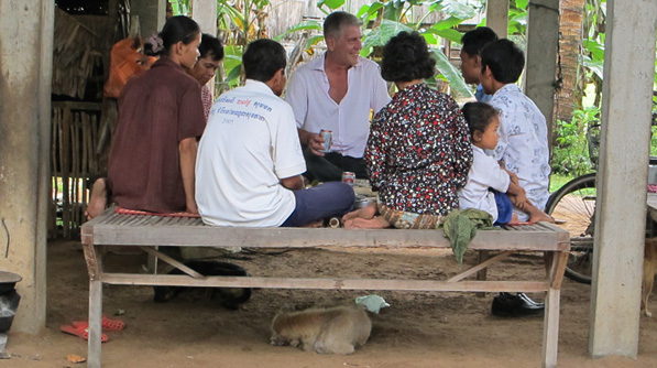 Tony enjoys a meal with a rice-farming family in Cambodia