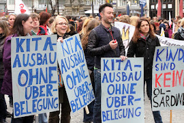 Kitabeschäftigte mit Protestplakaten.