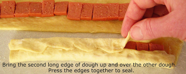 folding the second side of dough over the hot dogs. 