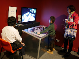 boy at the Tyrannosaurus Command Centre playing with controls and looking at live video of the area around the Tyrannosaurus