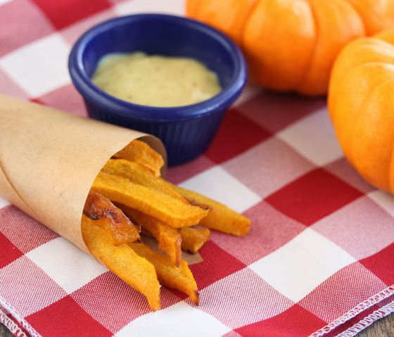a close-up of pumpkin fries in a brown paper cone