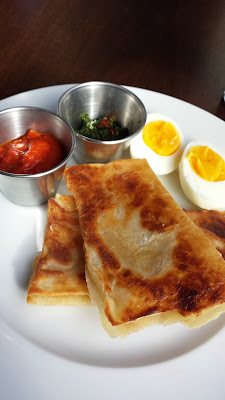 Cafe Castagna brunch item of malawach, served with tomato sauce, zhoug, hard boiled egg. A Malawach is a thin folded pastry that is fried, sort of a mashup between a pita or naan and phyllo dough