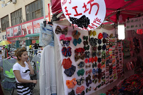 woman talking on phone next to colorful bows for sale