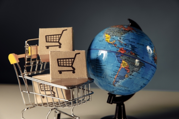 globe-supermarket-shopping-cart-with-boxes-laptop-background-online-shopping-concept