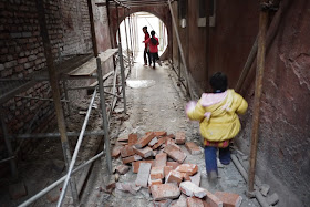three children running through a construction area
