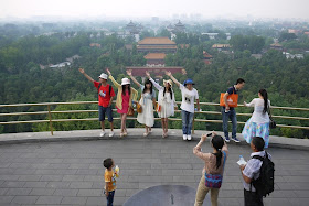 5 people posing with outstretched arms for a photo at Jingshan Park