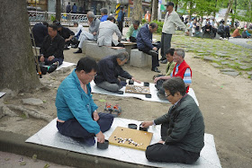 two men playing baduk (Go) at Jongmyo Park in Seoul