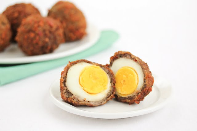 photo of a scotch egg sliced in half on a plate