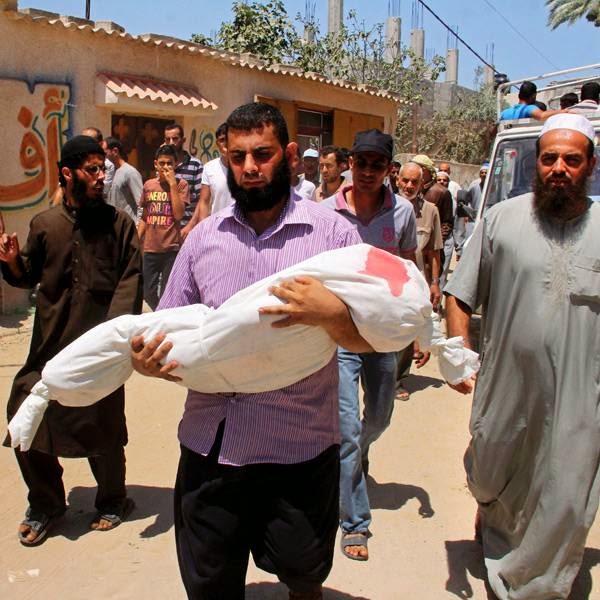 A Palestinian relative carries the body of Mary Idhair, 7, who was killed along with over a dozen members from her extended family in an Israeli strike, during their funerals in Rafah, Gaza Strip.