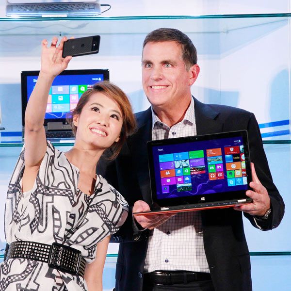 Intel Corporation's Executive Vice President Tom Kilroy (R) holds a tablet/laptop hybrid for a photo call with Taiwanese pop star Jolin Tsai during the opening of Taiwan's Computex 2013, one of the world's largest IT exhibitions, in Taipei, Taiwan.