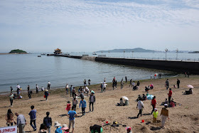 Qingdao's Huilan Pavilion and pier with a beach in the foreground