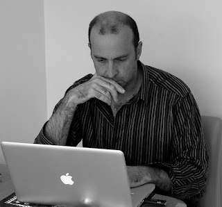 a man sitting at a desk with his hand on his chin