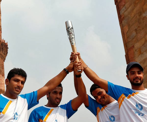 (From L to R) Indian field hockey players Sk Uthappa, Dharamvir Singh, PT Rao and Harhir Singh pose as they hold the Commonwealth Games Baton at 13th century Qutub Minar, one of the main tourist attractions in New Delhi October 13, 2013. 