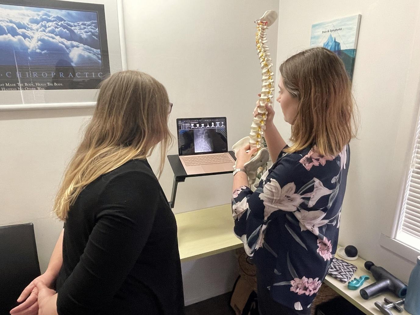 A person looking at a spine model

Description automatically generated with low confidence