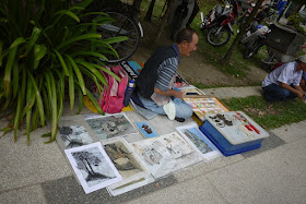man selling drawings at an outdoor market in George Town, Penang, Malaysia