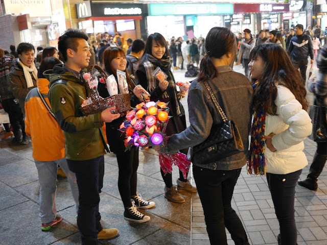 to young women inquiring about purchasing colored flowers which light up