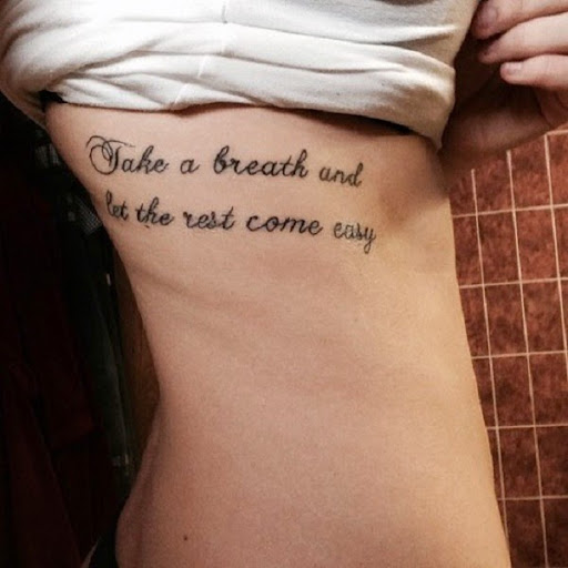 small quotes tattoo on side ribcage