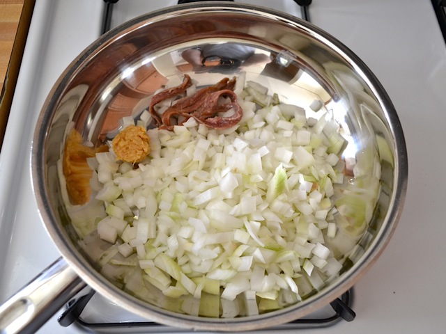 aromatic ingredients and onions in large pan cooking 