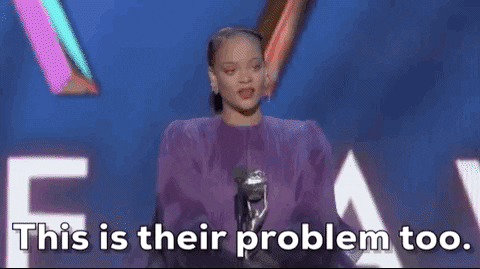 Rihanna on stage at an award ceremony standing behind a microphone saying "This is their problem too."