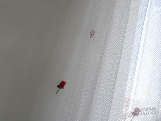 Decorar con rosas una cortina de visillo.
