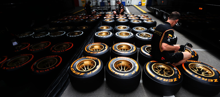 Mecánicos de Lotus inspeccionan los neumáticos Pirelli en el paddock