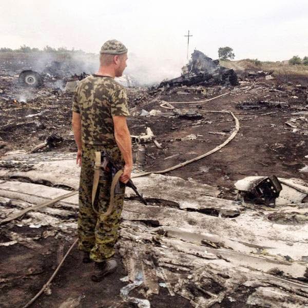 An armed pro-Russian separatist stands at a site of a Malaysia Airlines Boeing 777 plane crash in the settlement of Grabovo in the Donetsk region, July 17, 2014. 