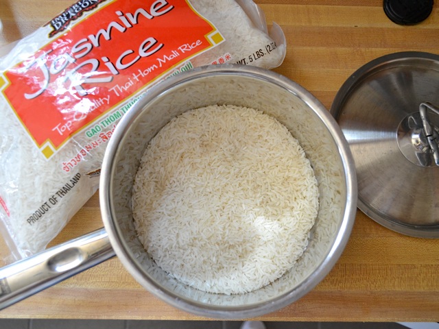 jasmine rice in pot with package of rice in background 