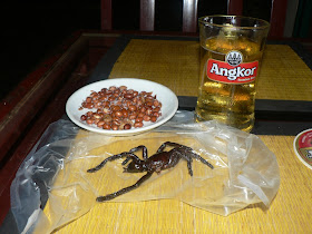 cooked tarantula spider, peanuts, and a glass of beer