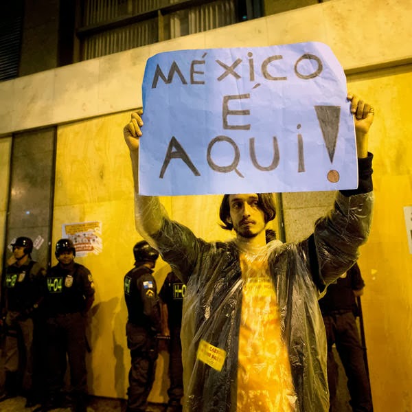 A man holds a sign that reads in Portuguese 'Mexico is here' referred to a similar teacher's strike in Mexico during a demonstrator in support of Brazilian teachers on strik in Rio de Janeiro, Brazil.