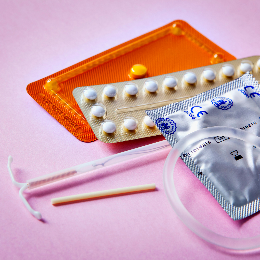 Different forms of birth control options while breastfeeding against a plain pink background