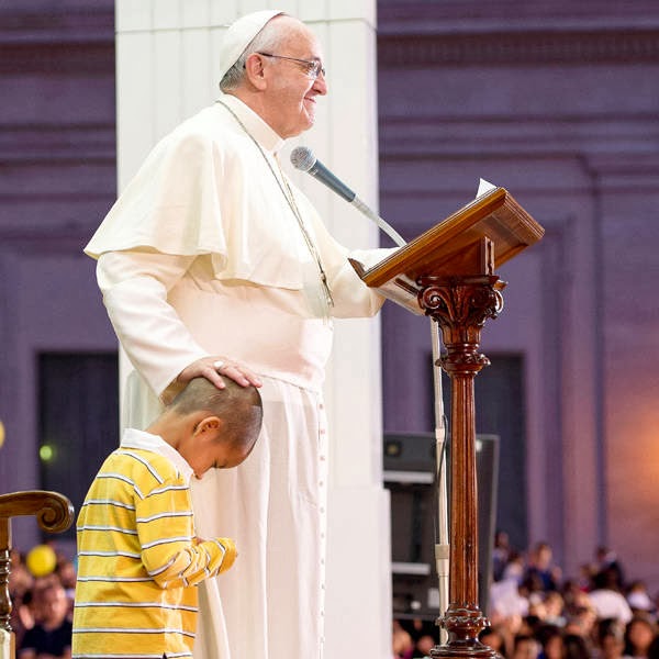 Acting like an indulgent grandpa, Francis let the boy explore the area undisturbed before tens of thousands of people. The pope smiled while reading his speech as the boy sat in the empty chair, gazed up at him and even at one point clung to the pontiff's legs.