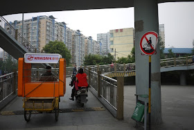 sign with slash through a person on a bike with an arrow below the bike pointing to the left