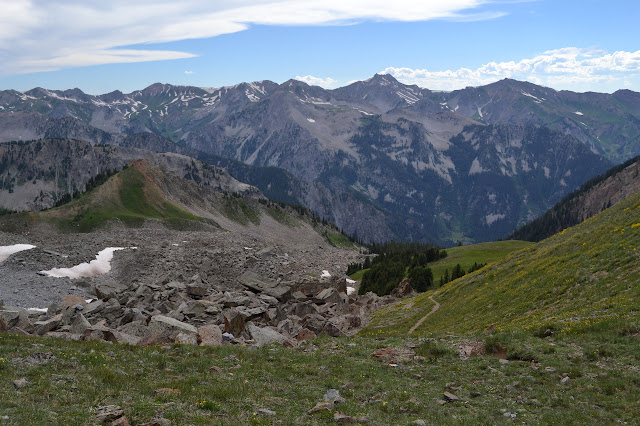 trail dropping down the other side with a range of peaks in the background