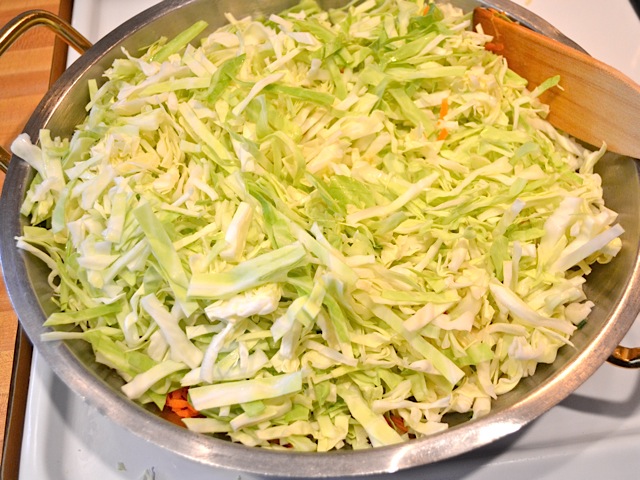 shredded cabbage added to pan of ingredients 