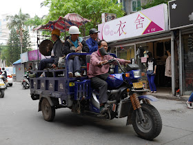 musician playing on a large tricycle cart on Nian Li Festival (年例节) in Maoming, China