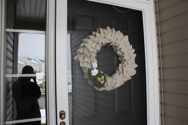 The closed front door with the wreath hanging on it.