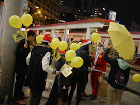 group dressed in Christmas spirit carrying various Umbrella Movement items