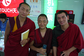 three Tibetan monks, one holding an iPhone, in Xining, Qinghai, China