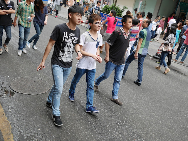 young men walking on a street in Dongmen