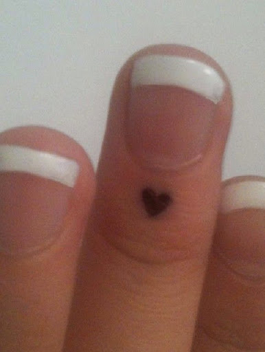 small heart tattoo on finger