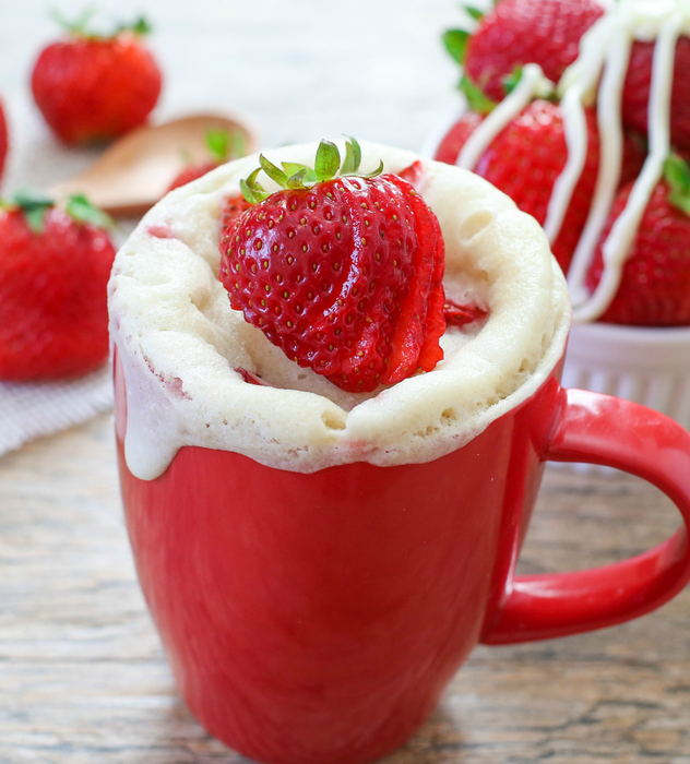 photo of a Strawberries and Cream Mug Cake topped with fresh strawberries