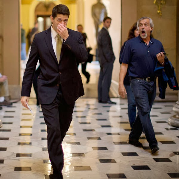 A tourist (R) reacts as U.S. Representative Paul Ryan walks in Statuary Hall on Capitol Hill in Washington.