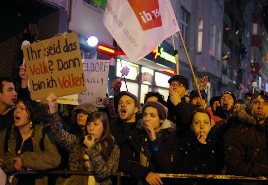 Demonstrantinnen mit Ver.di-Fahne und Transparent: »Ihr seid das Volk? Dann bin ich Volker!«.